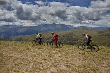 Peru, Cusco 'da antik dağlık patikalar boyunca seyahat eden bir grup dağ bisikletçisi, otantik yerel kültür, tarihi manzaralar ve uzak bir And ortamında aktif bir yaşam tarzı ve keşif ruhunu yansıtan açık hava maceraları yaşıyorlar..