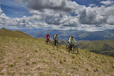 Peru, Cusco 'da antik dağlık patikalar boyunca seyahat eden bir grup dağ bisikletçisi, otantik yerel kültür, tarihi manzaralar ve uzak bir And ortamında aktif bir yaşam tarzı ve keşif ruhunu yansıtan açık hava maceraları yaşıyorlar..