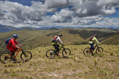 Peru, Cusco 'da antik dağlık patikalar boyunca seyahat eden bir grup dağ bisikletçisi, otantik yerel kültür, tarihi manzaralar ve uzak bir And ortamında aktif bir yaşam tarzı ve keşif ruhunu yansıtan açık hava maceraları yaşıyorlar..