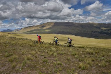 Peru, Cusco 'da antik dağlık patikalar boyunca seyahat eden bir grup dağ bisikletçisi, otantik yerel kültür, tarihi manzaralar ve uzak bir And ortamında aktif bir yaşam tarzı ve keşif ruhunu yansıtan açık hava maceraları yaşıyorlar..