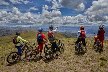 Peru, Cusco 'da antik dağlık patikalar boyunca seyahat eden bir grup dağ bisikletçisi, otantik yerel kültür, tarihi manzaralar ve uzak bir And ortamında aktif bir yaşam tarzı ve keşif ruhunu yansıtan açık hava maceraları yaşıyorlar..