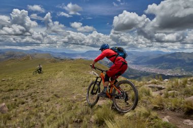 Peru, Cusco 'da antik dağlık patikalar boyunca seyahat eden bir grup dağ bisikletçisi, otantik yerel kültür, tarihi manzaralar ve uzak bir And ortamında aktif bir yaşam tarzı ve keşif ruhunu yansıtan açık hava maceraları yaşıyorlar..