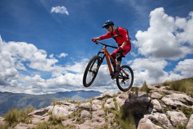 Peru, Cusco 'da antik dağlık patikalar boyunca seyahat eden bir grup dağ bisikletçisi, otantik yerel kültür, tarihi manzaralar ve uzak bir And ortamında aktif bir yaşam tarzı ve keşif ruhunu yansıtan açık hava maceraları yaşıyorlar..