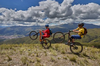 Peru, Cusco 'da antik dağlık patikalar boyunca seyahat eden bir grup dağ bisikletçisi, otantik yerel kültür, tarihi manzaralar ve uzak bir And ortamında aktif bir yaşam tarzı ve keşif ruhunu yansıtan açık hava maceraları yaşıyorlar..