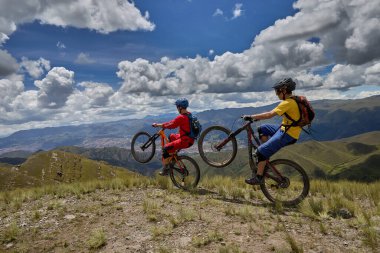 Peru, Cusco 'da antik dağlık patikalar boyunca seyahat eden bir grup dağ bisikletçisi, otantik yerel kültür, tarihi manzaralar ve uzak bir And ortamında aktif bir yaşam tarzı ve keşif ruhunu yansıtan açık hava maceraları yaşıyorlar..
