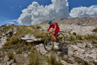 Peru, Cusco 'da antik dağlık patikalar boyunca seyahat eden bir grup dağ bisikletçisi, otantik yerel kültür, tarihi manzaralar ve uzak bir And ortamında aktif bir yaşam tarzı ve keşif ruhunu yansıtan açık hava maceraları yaşıyorlar..