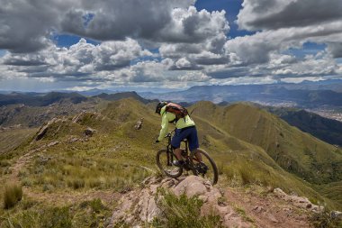 Peru, Cusco 'da antik dağlık patikalar boyunca seyahat eden bir grup dağ bisikletçisi, otantik yerel kültür, tarihi manzaralar ve uzak bir And ortamında aktif bir yaşam tarzı ve keşif ruhunu yansıtan açık hava maceraları yaşıyorlar..