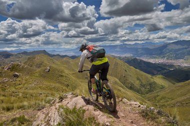 Peru, Cusco 'da antik dağlık patikalar boyunca seyahat eden bir grup dağ bisikletçisi, otantik yerel kültür, tarihi manzaralar ve uzak bir And ortamında aktif bir yaşam tarzı ve keşif ruhunu yansıtan açık hava maceraları yaşıyorlar..