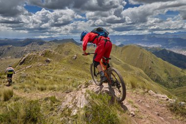 Peru, Cusco 'da antik dağlık patikalar boyunca seyahat eden bir grup dağ bisikletçisi, otantik yerel kültür, tarihi manzaralar ve uzak bir And ortamında aktif bir yaşam tarzı ve keşif ruhunu yansıtan açık hava maceraları yaşıyorlar..