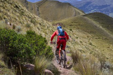 Peru, Cusco 'da antik dağlık patikalar boyunca seyahat eden bir grup dağ bisikletçisi, otantik yerel kültür, tarihi manzaralar ve uzak bir And ortamında aktif bir yaşam tarzı ve keşif ruhunu yansıtan açık hava maceraları yaşıyorlar..