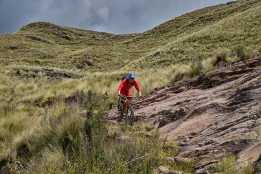 Peru, Cusco 'da antik dağlık patikalar boyunca seyahat eden bir grup dağ bisikletçisi, otantik yerel kültür, tarihi manzaralar ve uzak bir And ortamında aktif bir yaşam tarzı ve keşif ruhunu yansıtan açık hava maceraları yaşıyorlar..