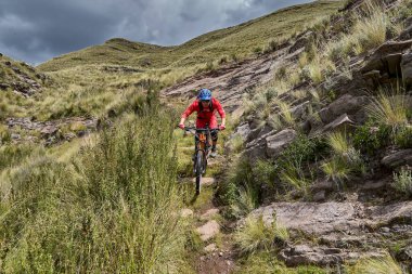 Peru, Cusco 'da antik dağlık patikalar boyunca seyahat eden bir grup dağ bisikletçisi, otantik yerel kültür, tarihi manzaralar ve uzak bir And ortamında aktif bir yaşam tarzı ve keşif ruhunu yansıtan açık hava maceraları yaşıyorlar..