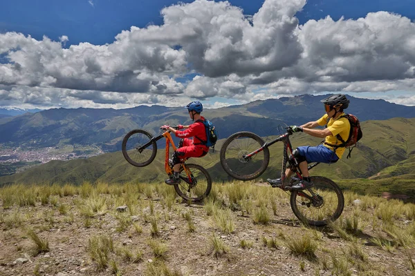 Peru, Cusco 'da antik dağlık patikalar boyunca seyahat eden bir grup dağ bisikletçisi, otantik yerel kültür, tarihi manzaralar ve uzak bir And ortamında aktif bir yaşam tarzı ve keşif ruhunu yansıtan açık hava maceraları yaşıyorlar..