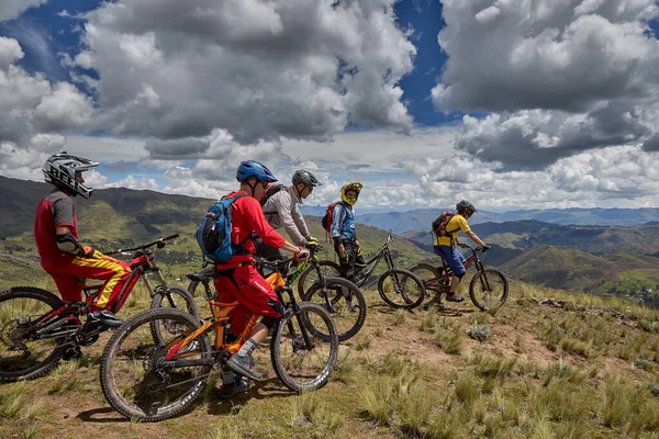 Peru, Cusco 'da antik dağlık patikalar boyunca seyahat eden bir grup dağ bisikletçisi, otantik yerel kültür, tarihi manzaralar ve uzak bir And ortamında aktif bir yaşam tarzı ve keşif ruhunu yansıtan açık hava maceraları yaşıyorlar..