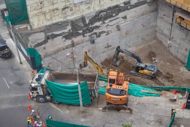 Miraflores 'te büyük bir inşaat sahasında faaliyet gösteren kazıcılar, büyüyen bir şehir ortamında güvenli çalışma uygulamaları, modern inşaat standartları ve kentsel emlak gelişimini gösteriyorlar..