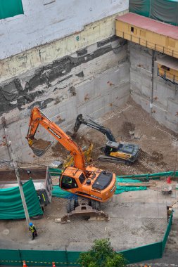 Miraflores 'te büyük bir inşaat sahasında faaliyet gösteren kazıcılar, büyüyen bir şehir ortamında güvenli çalışma uygulamaları, modern inşaat standartları ve kentsel emlak gelişimini gösteriyorlar..