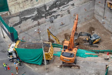 Miraflores 'te büyük bir inşaat sahasında faaliyet gösteren kazıcılar, büyüyen bir şehir ortamında güvenli çalışma uygulamaları, modern inşaat standartları ve kentsel emlak gelişimini gösteriyorlar..