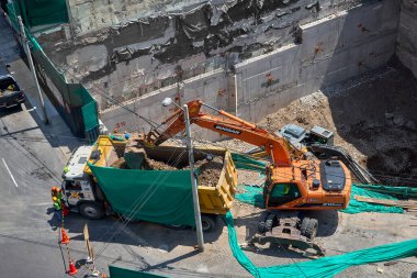 Miraflores 'te büyük bir inşaat sahasında faaliyet gösteren kazıcılar, büyüyen bir şehir ortamında güvenli çalışma uygulamaları, modern inşaat standartları ve kentsel emlak gelişimini gösteriyorlar..