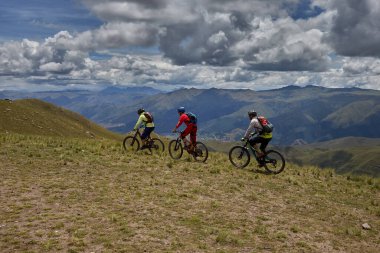 Peru, Cusco 'da antik dağlık patikalar boyunca seyahat eden bir grup dağ bisikletçisi, otantik yerel kültür, tarihi manzaralar ve uzak bir And ortamında aktif bir yaşam tarzı ve keşif ruhunu yansıtan açık hava maceraları yaşıyorlar..