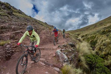 Peru, Cusco 'da antik dağlık patikalar boyunca seyahat eden bir grup dağ bisikletçisi, otantik yerel kültür, tarihi manzaralar ve uzak bir And ortamında aktif bir yaşam tarzı ve keşif ruhunu yansıtan açık hava maceraları yaşıyorlar..