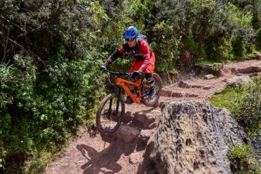 Peru, Cusco 'da antik dağlık patikalar boyunca seyahat eden bir grup dağ bisikletçisi, otantik yerel kültür, tarihi manzaralar ve uzak bir And ortamında aktif bir yaşam tarzı ve keşif ruhunu yansıtan açık hava maceraları yaşıyorlar..