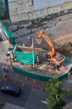 Miraflores 'te büyük bir inşaat sahasında faaliyet gösteren kazıcılar, büyüyen bir şehir ortamında güvenli çalışma uygulamaları, modern inşaat standartları ve kentsel emlak gelişimini gösteriyorlar..