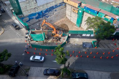 Miraflores 'te büyük bir inşaat sahasında faaliyet gösteren kazıcılar, büyüyen bir şehir ortamında güvenli çalışma uygulamaları, modern inşaat standartları ve kentsel emlak gelişimini gösteriyorlar..