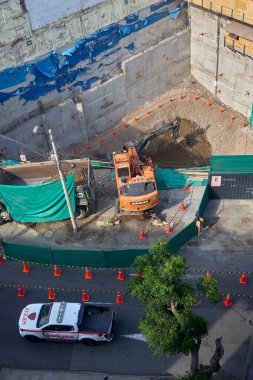 Miraflores 'te büyük bir inşaat sahasında faaliyet gösteren kazıcılar, büyüyen bir şehir ortamında güvenli çalışma uygulamaları, modern inşaat standartları ve kentsel emlak gelişimini gösteriyorlar..