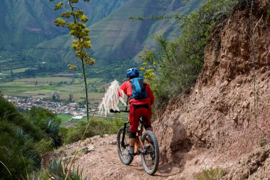 Peru, Cusco 'da antik dağlık patikalar boyunca seyahat eden bir grup dağ bisikletçisi, otantik yerel kültür, tarihi manzaralar ve uzak bir And ortamında aktif bir yaşam tarzı ve keşif ruhunu yansıtan açık hava maceraları yaşıyorlar..