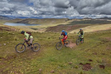 Peru 'nun kutsal vadisi Cusco' da sınırlarını Andean manzaraları ve antik tarım arazileriyle çevreleyen dağ bisikletçileri zorluyor. Bu dinamik açık hava sahnesi macera seyahatini yakalar.,
