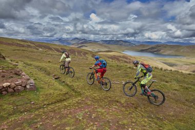 Peru 'nun kutsal vadisi Cusco' da sınırlarını Andean manzaraları ve antik tarım arazileriyle çevreleyen dağ bisikletçileri zorluyor. Bu dinamik açık hava sahnesi macera seyahatini yakalar.,