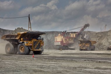 Büyük elektrikli halat küreği, açık kömür madenine ultra-sınıf bir maden kamyonu yüklüyor. Bu da yükleme döngüleri, ekipman konumlandırmaları ve kontrollü malzeme taşımacılığında en iyi uygulamaları gösteriyor..