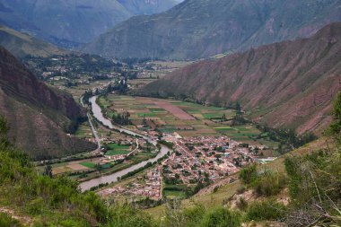 Peru 'nun Cusco yakınlarındaki Kutsal Vadi boyunca muazzam bir yüksek irtifa panoraması var. Yılan Urubamba Nehri çarpıcı çizgili bir dağ zirvesinin eteklerindeki antik tarım arazilerinin geniş bir kısmında esiyor.,