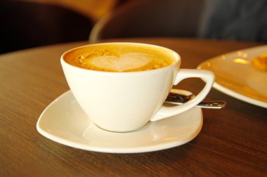 ahşap masa üzerinde beyaz fincan cappuccino sıcak kahve