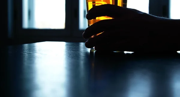 Bière verre tenant dans la main de l'homme dans la nuit noire — Photo