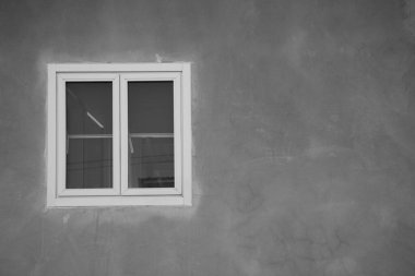 Gri çatı katı beton arka planlı beyaz çerçeve penceresi