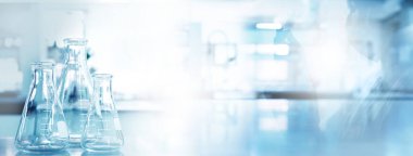 Tıp laboratuarında koruyucu gözlüklü, eldivenli bilim adamının maviliği ve gölgesi. 