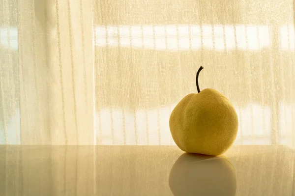 하나의 열매는 햇빛이 감도는 커튼을 배경으로 여전히 — 스톡 사진
