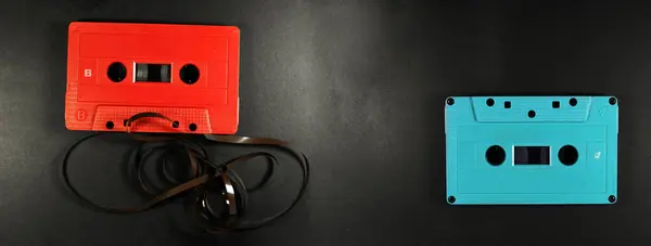ヴィンテージかレトロな赤と青のカセットテープブラックライトバナーの背景 — ストック写真