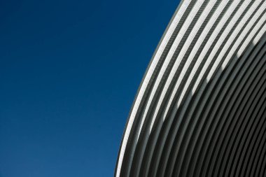 modern contemporary white grey metal curve architecture on blue sky background