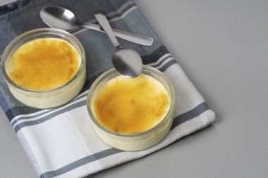 Tahta masaya kaşık konmuş Creme brulee. Fransa 'da meşhur, İspanyol Crema Catalana' sı gibi lezzetli bir tatlı. .