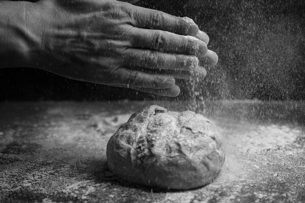 Хлеб летать с мукой всплеск на пышном фоне. Творческая концепция пекарни, выпечки и приготовления пищи. Черно-белые цвета.