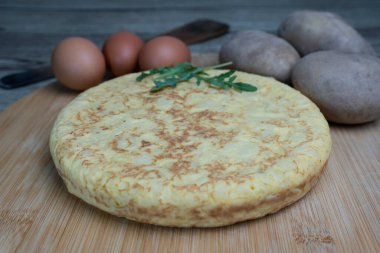 Tahta tahtada taze patates ve yumurta ile birlikte tortilla de patatas adı verilen lezzetli İspanyol omleti. Yakın plan İspanyol mutfağı konsepti..