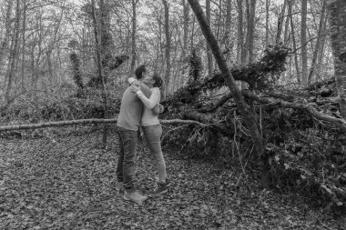 Güzel bir ormanda sarılıp gülen mutlu genç çift. Romantik, aşk ve arkadaşlık yaşam tarzı. Siyah-beyaz fotoğraf...