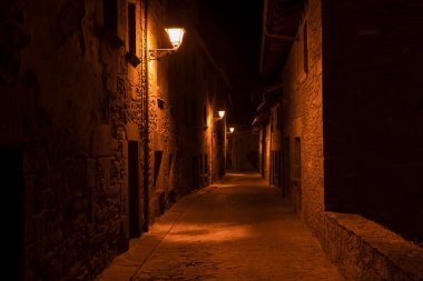 Antik ortaçağ köyü Rupit, Barselona, İspanya 'da lambaların yandığı eski taş caddenin muhteşem gece manzarası. Avrupa' da seyahat kavramı, kırsal arka plan.