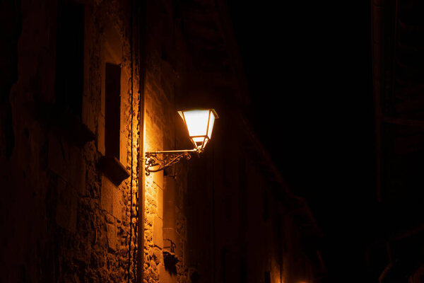 Night view of old street with yellow lamp in Rupit old spanish village near Barcelona.