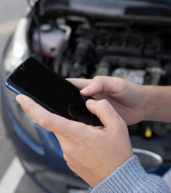 Kadın ellerinin telefon konuşması, mesajlaşma ya da araç arızası üstüne araba sigortası kullanarak yol yardımı almaları. Onarım ve kaza sorunları konsepti yaşam tarzı.