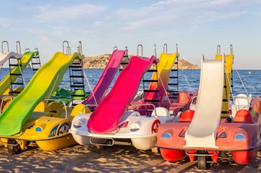 Yaz tatili konsepti arka planda. Pedal botları veya plaj kumu üzerinde yüzen tekneler. Akdeniz, İspanya.