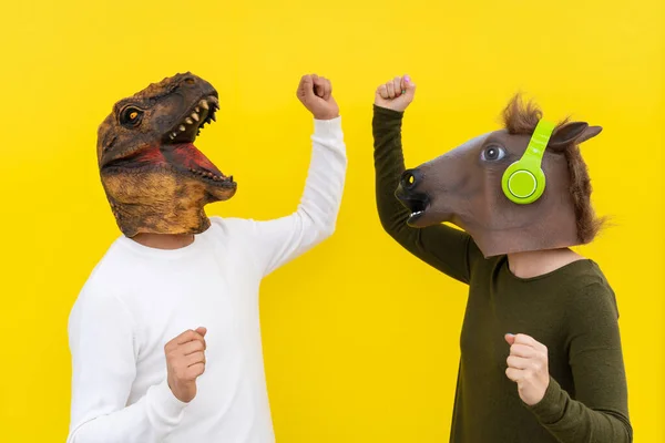 Glückliche Männer Und Frauen Mit Dinosaurier Und Pferdekopfmaske Tanzen Aktives Stockfoto