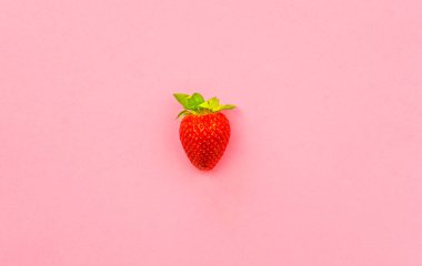 Çilek, pembe pastel arka planda izole edilmiş. Boş minimum düz katman. Fotokopi alanı ile sağlıklı gıda kavramı..